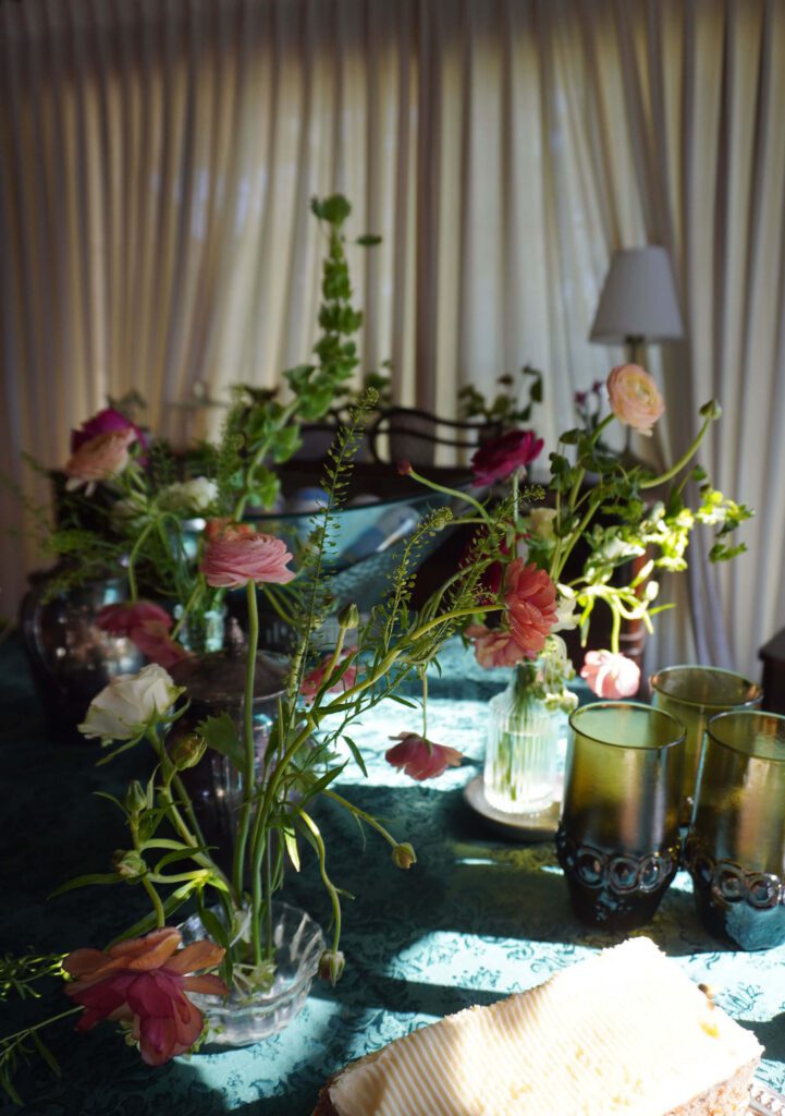 wedding flowers and green vintage glasses on blue table linens. 