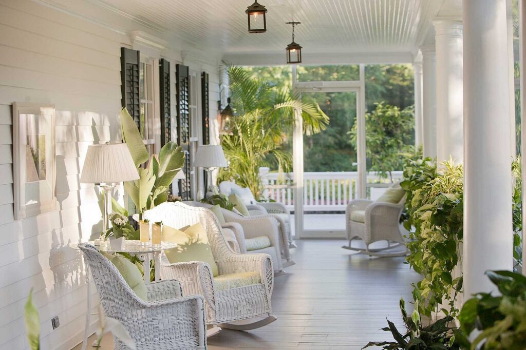 Charming covered porch at Mayflower Inn with white wicker seating and garden views