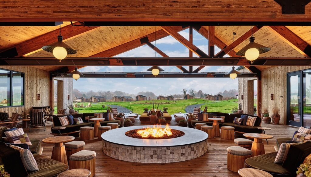 Cozy interior lounge with central stone fire pit at Wildflower Farms, Auberge Resorts Collection