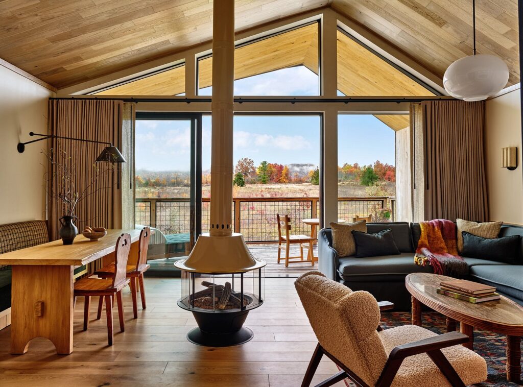 Spacious luxury guest room at Wildflower Farms with floor-to-ceiling windows and refined, nature-inspired décor